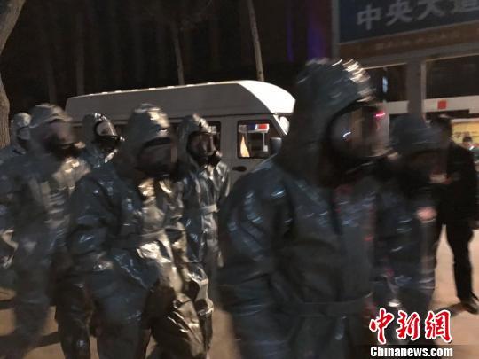 十几名身着防护服的人员头戴面具进入事发地。　胡健 摄